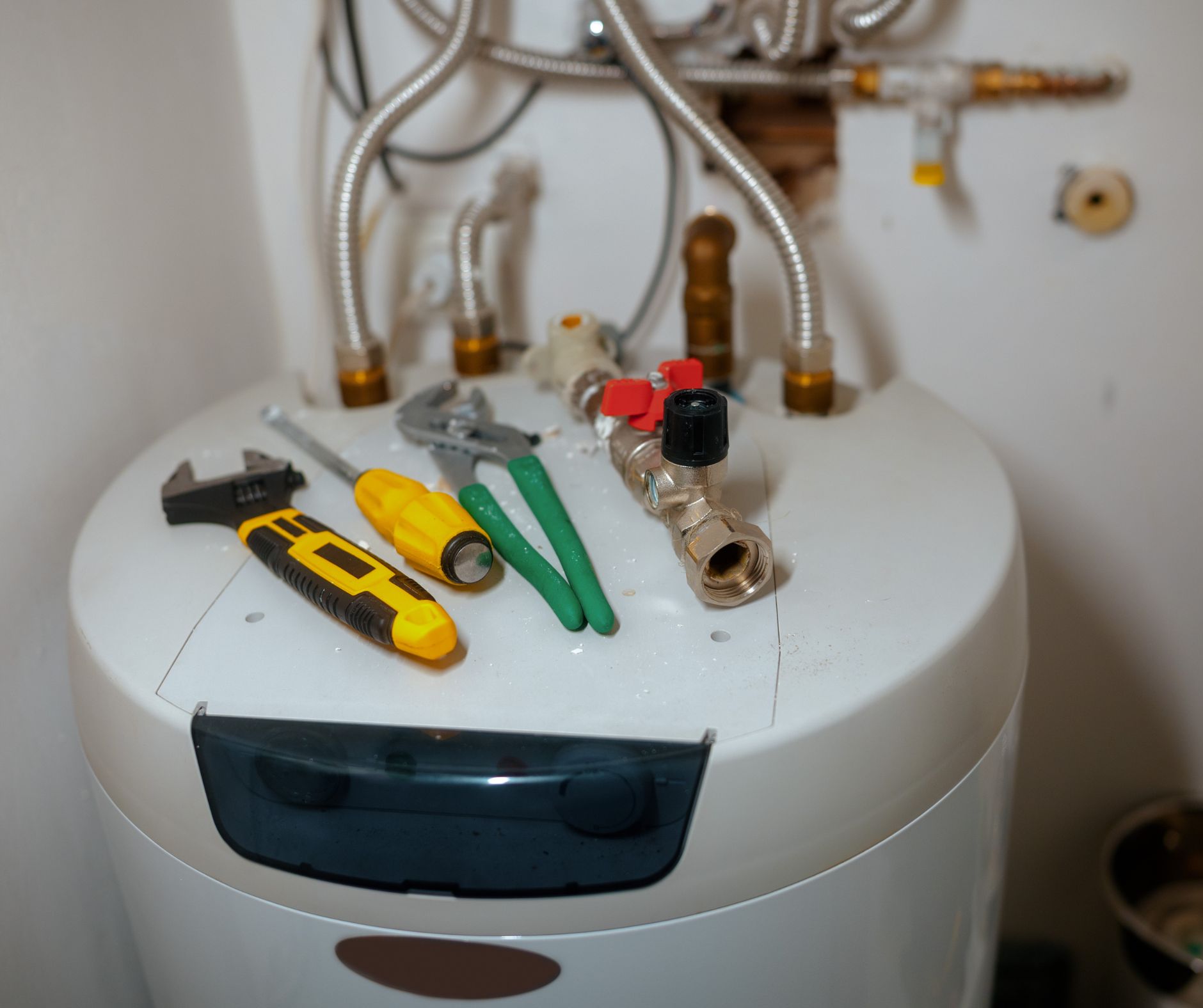 Water heater repair with tools on top of tank unit
