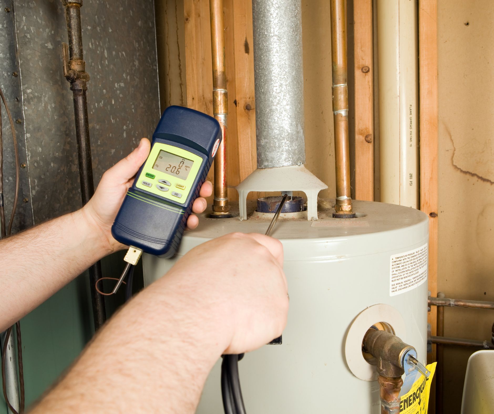 Technician testing water heater performance with diagnostic tool