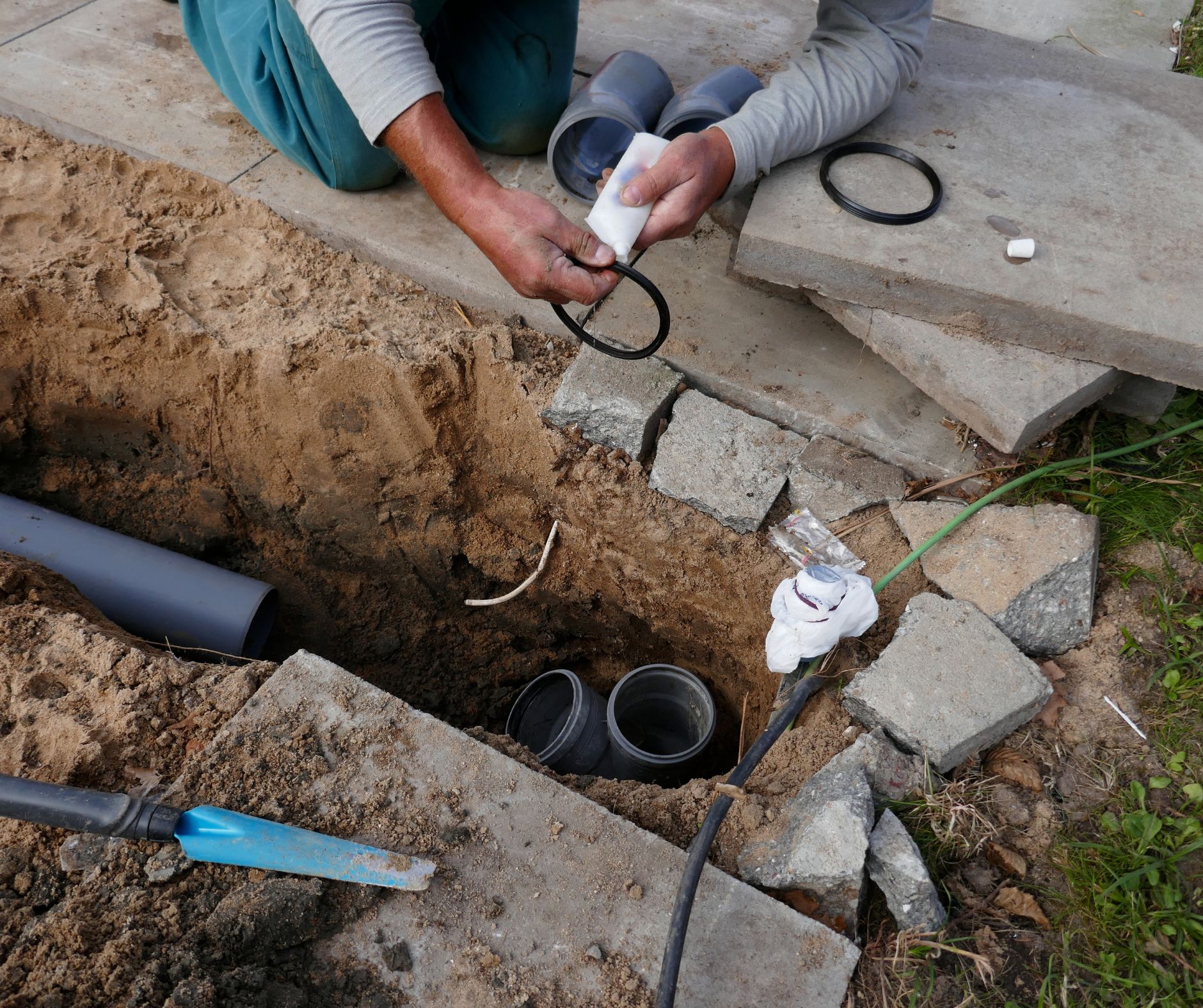 Plumber preparing sewer pipe connection during underground repair